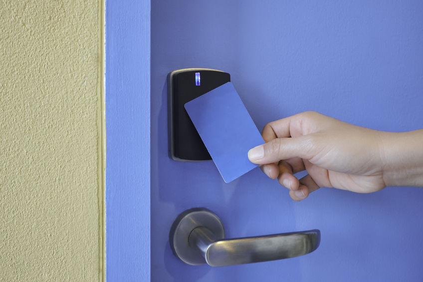 Man Using Key Card To Unlock Door